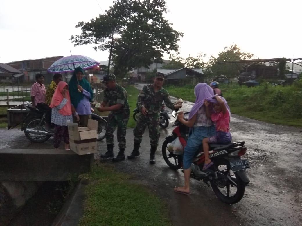 Meskipun Diguyur Hujan, Babinsa Tetap Bagi – Bagi Takjil Untuk Warga