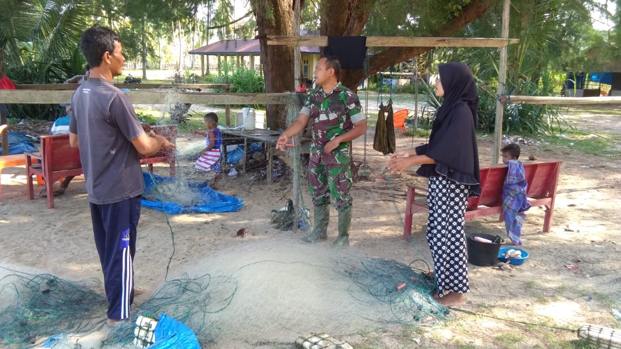 Rusak Tersangkut Karang, Babinsa Bantu Nelayan Perbaiki Jaring Ikan