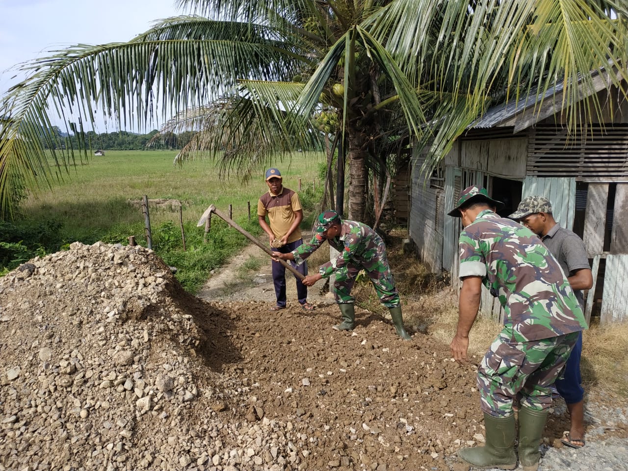 Babinsa Bantu Ratakan Tumpukan Tanah