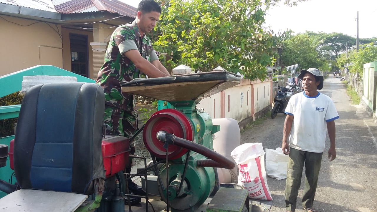Babinsa Indra Jaya Bantu Warga Giling Padi