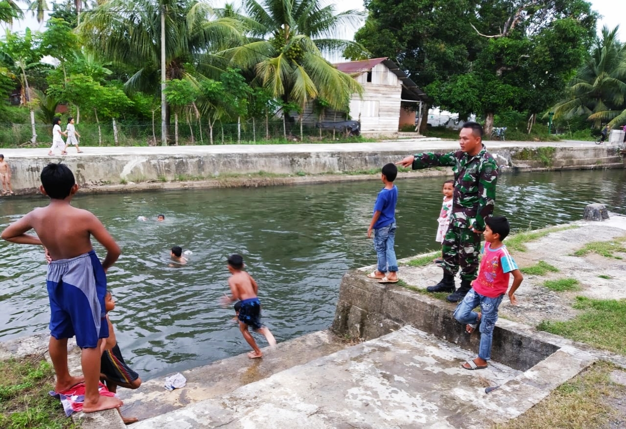 Peduli Keselamatan, Babinsa Lamno Pantau Anak – Anak Mandi di Sungai