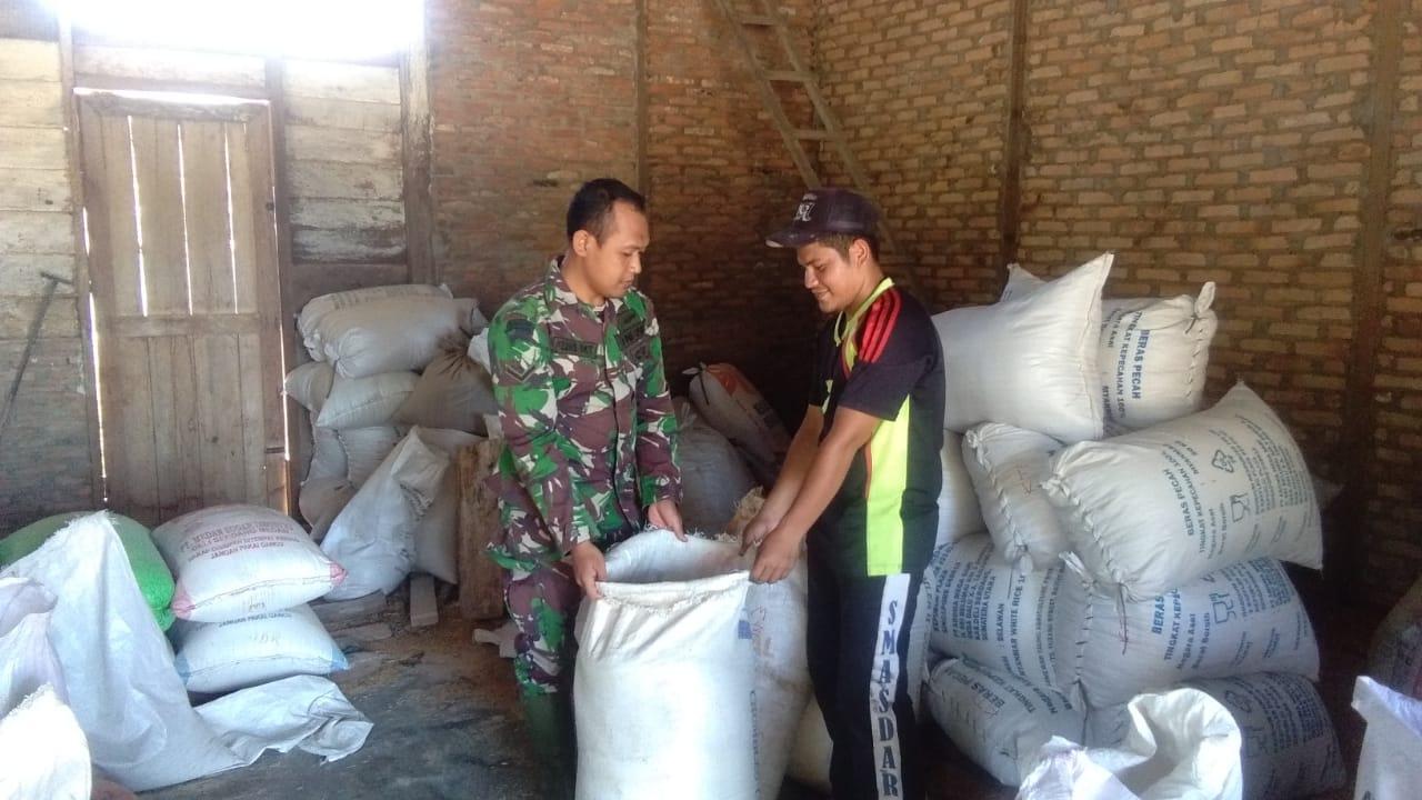 Sambut Lebaran, Serda Febri Bantu Warga Giling Padi