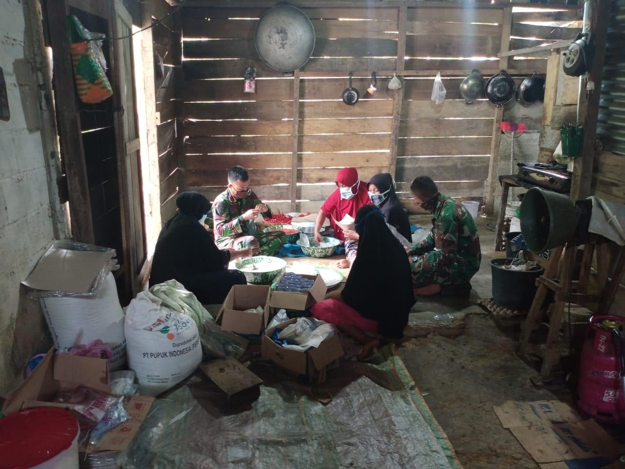 Kebersamaan Ibu-Ibu Desa Lango Bersama Satgas TMMD Menyiapkan Nasi Bungkus