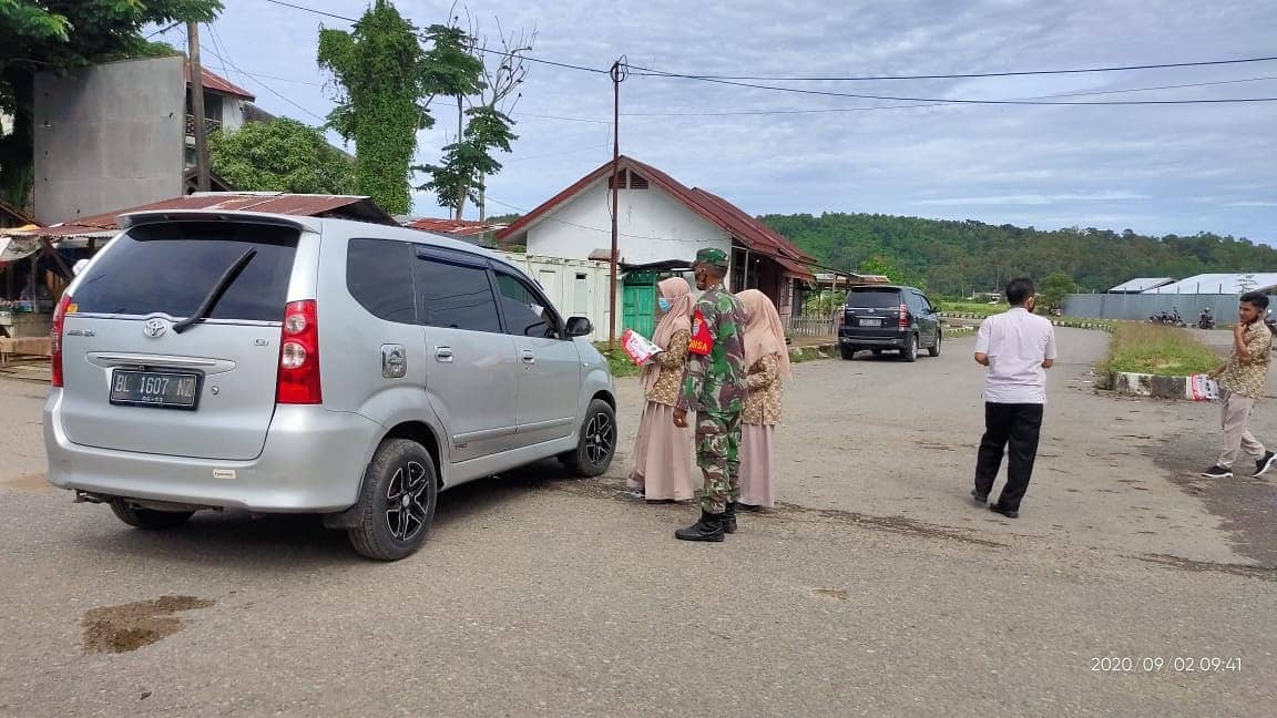 Babinsa dan Pelajar Bagikan Brosur Gebrak Masker Aceh