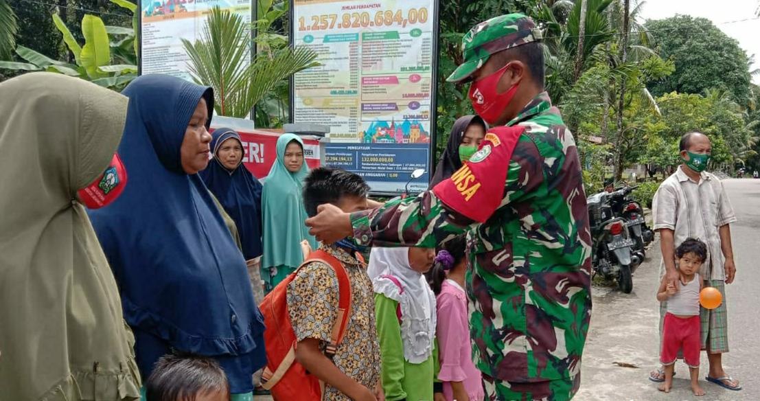 Cegah Covid-19, Babinsa Koramil 10/Labar Bersama Pemdes Bagi-bagi Masker Kepada Masyarakat