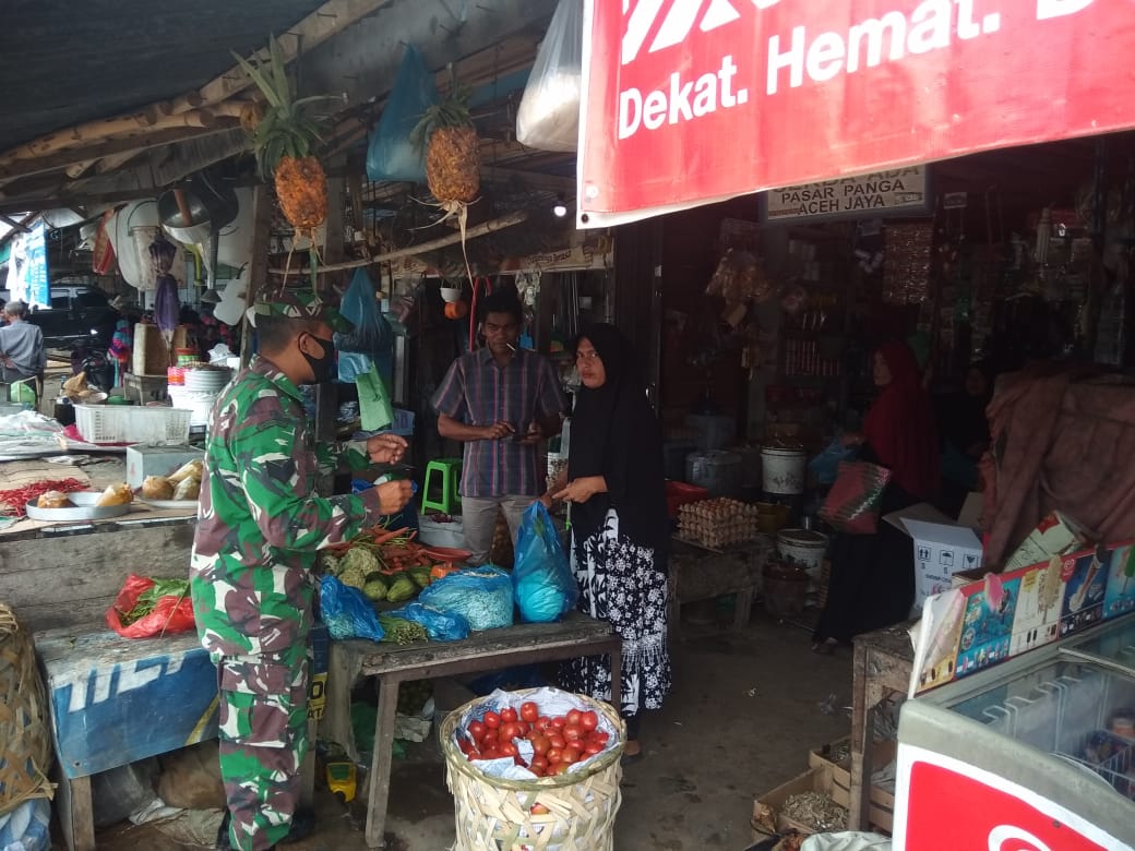 Babinsa Koramil 05/Panga Himbau Warga Pakai Makser di Pasar Keude Panga
