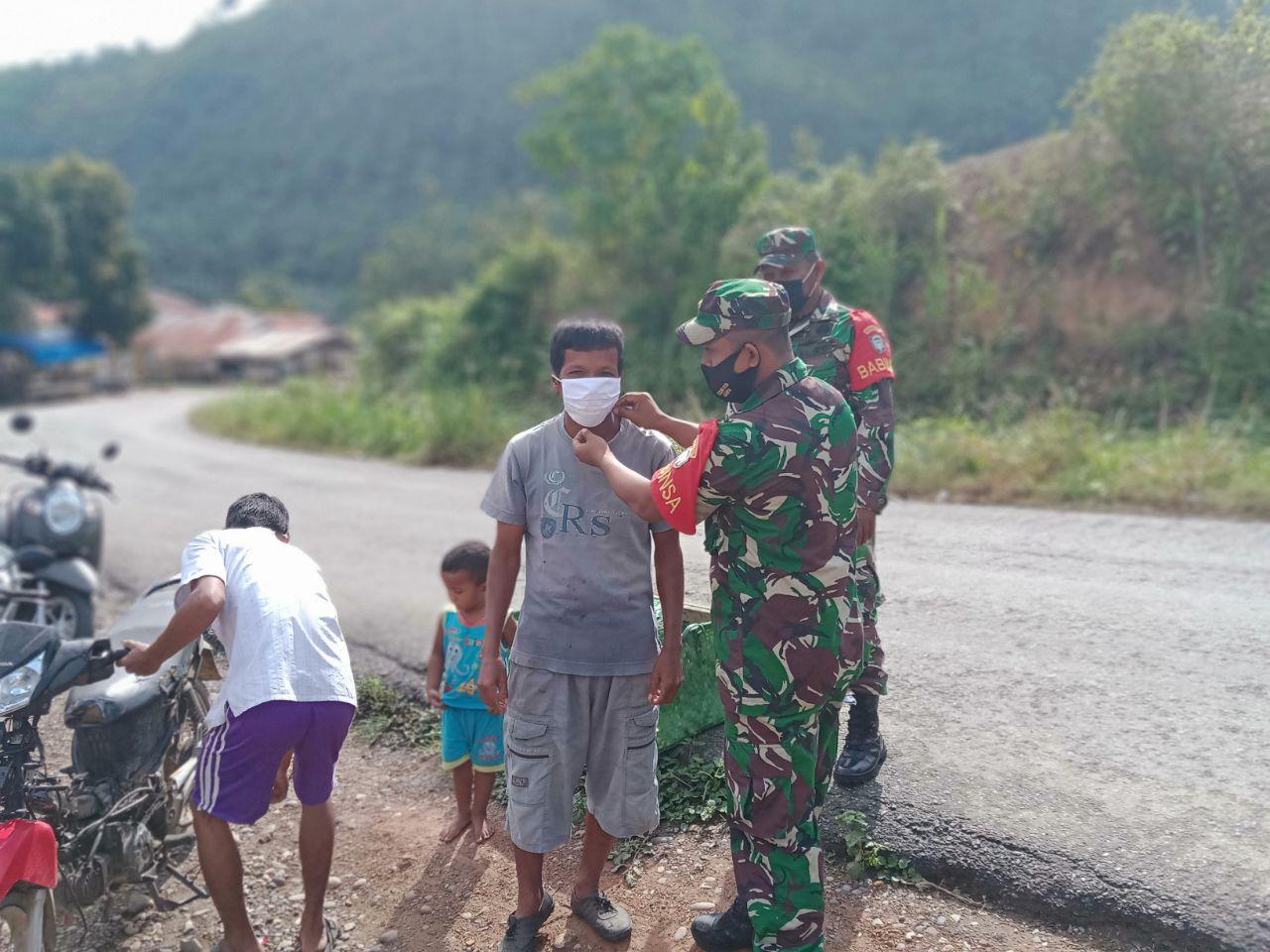 Babinsa Sosialisasikan New Normal Melalui Pembagian Masker Kepada Masyarakat
