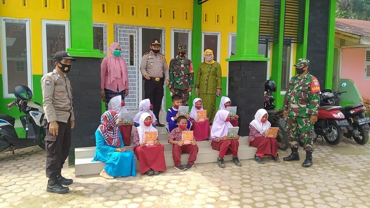 Peduli Dunia Pendidikan, Babinsa Dampingi Kapolsek Bagi-Bagi Buku Bacaan