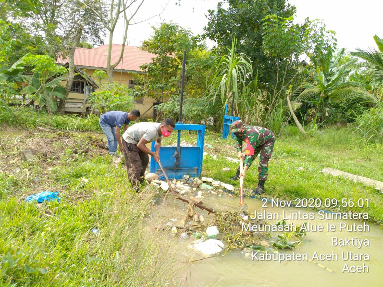 Babinsa koramil 13/baktiya bantu petani membersihkan saluran air.