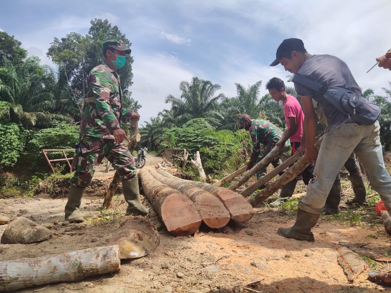 Jembatan terputus Pasca Banjir, Babinsa Koramil 27/GRP Bersama Gotong Royong untuk Memperbaikinya