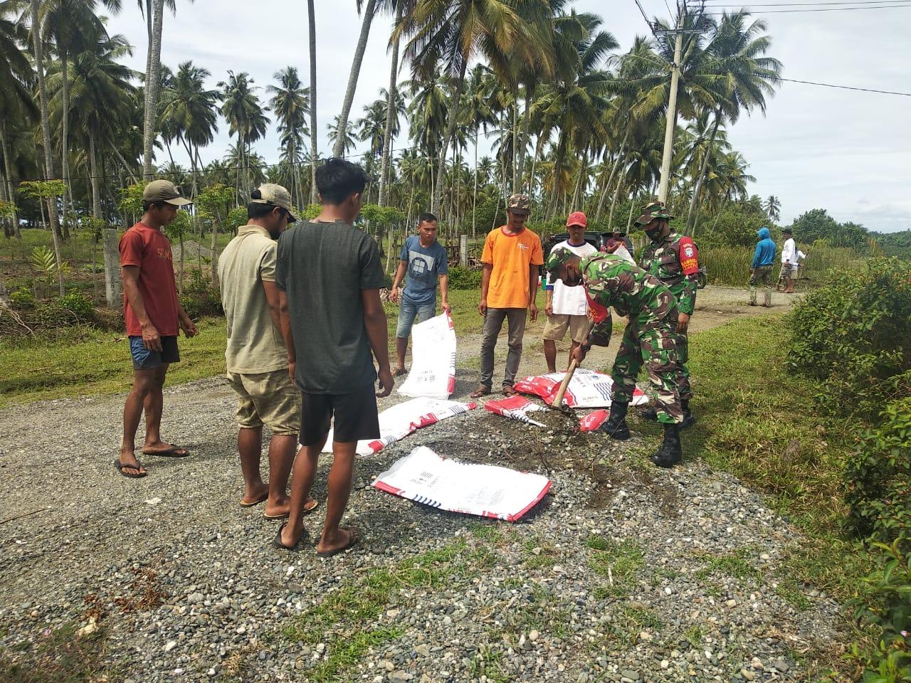 Anggota Koramil 09/Samatiga Gotong-Royong Bersama Warga Timbun Jalan Berlubang