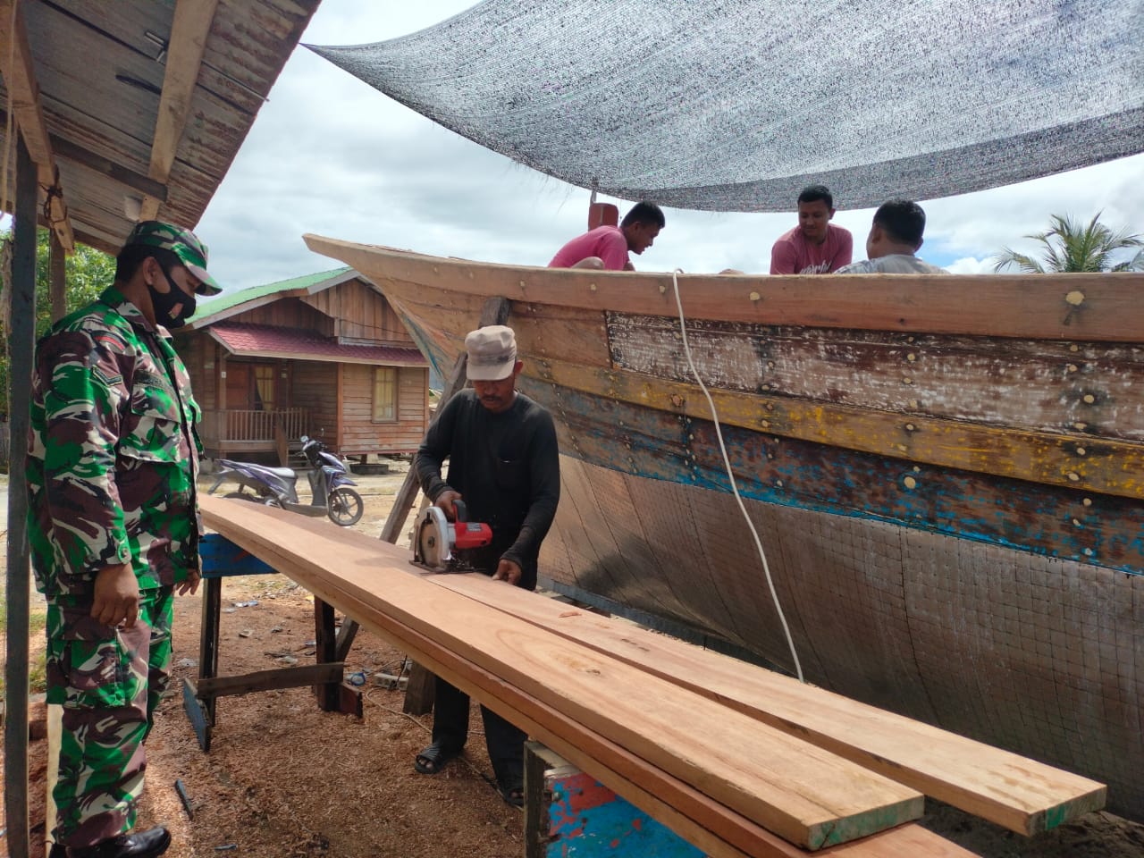 Penuh Keakraban Babinsa Komsos bersama Pembuat Kapal Nelayan Tradisional