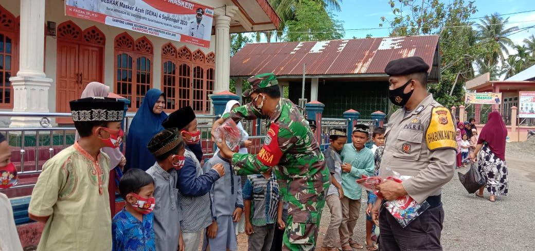 Sinergitas Babinsa dan Bhabinkamtibmas Bagikan Masker Untuk Anak-Anak