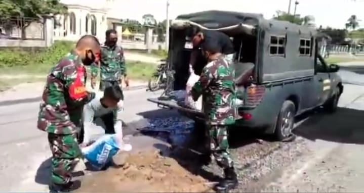 Peduli Akan Kondisi Jalan Berlubang, Babinsa Koramil Blangpdie Bersama Warga Timbun Jalan Rusak