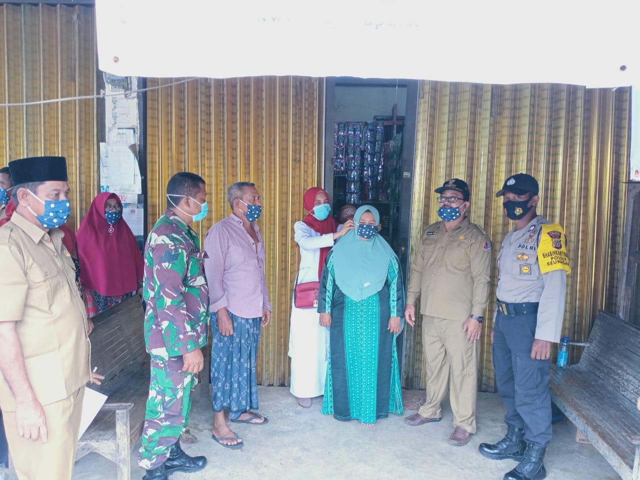 Babinsa dan Aparat Desa berikan Sosialisasi Prokes dan bagikan Masker kepada warganya