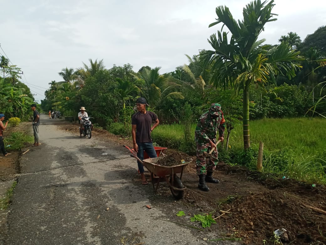 Babinsa Gotong-Royong Bantu Masyarakat Pelebaran Jalan Desa