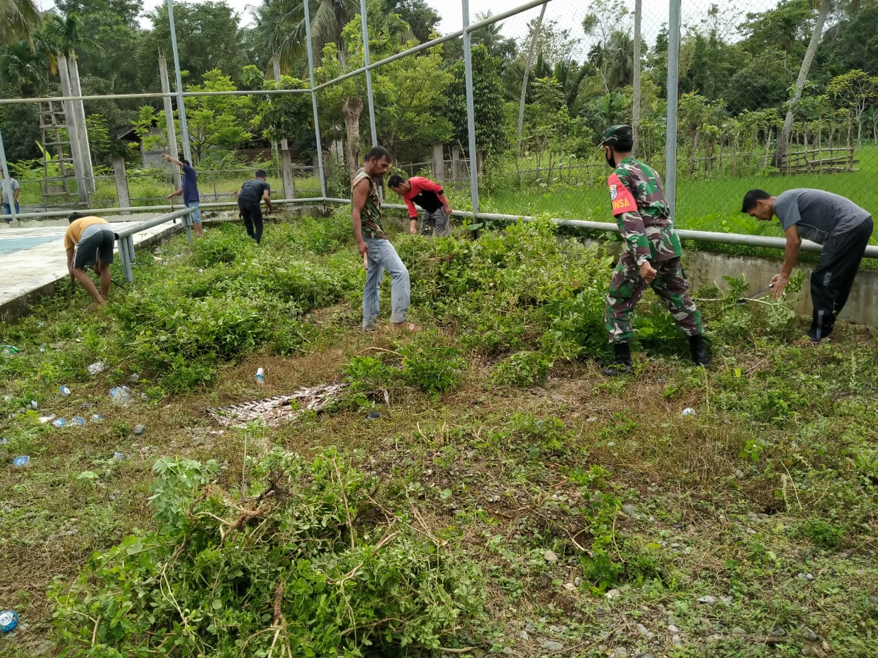 ANGGOTA KORAMIL 13/KEUMALA KODIM  0102/PIDIE BERSAMA WARGA MEMBERSIHKAN LAPANGAN BOLA VOLY