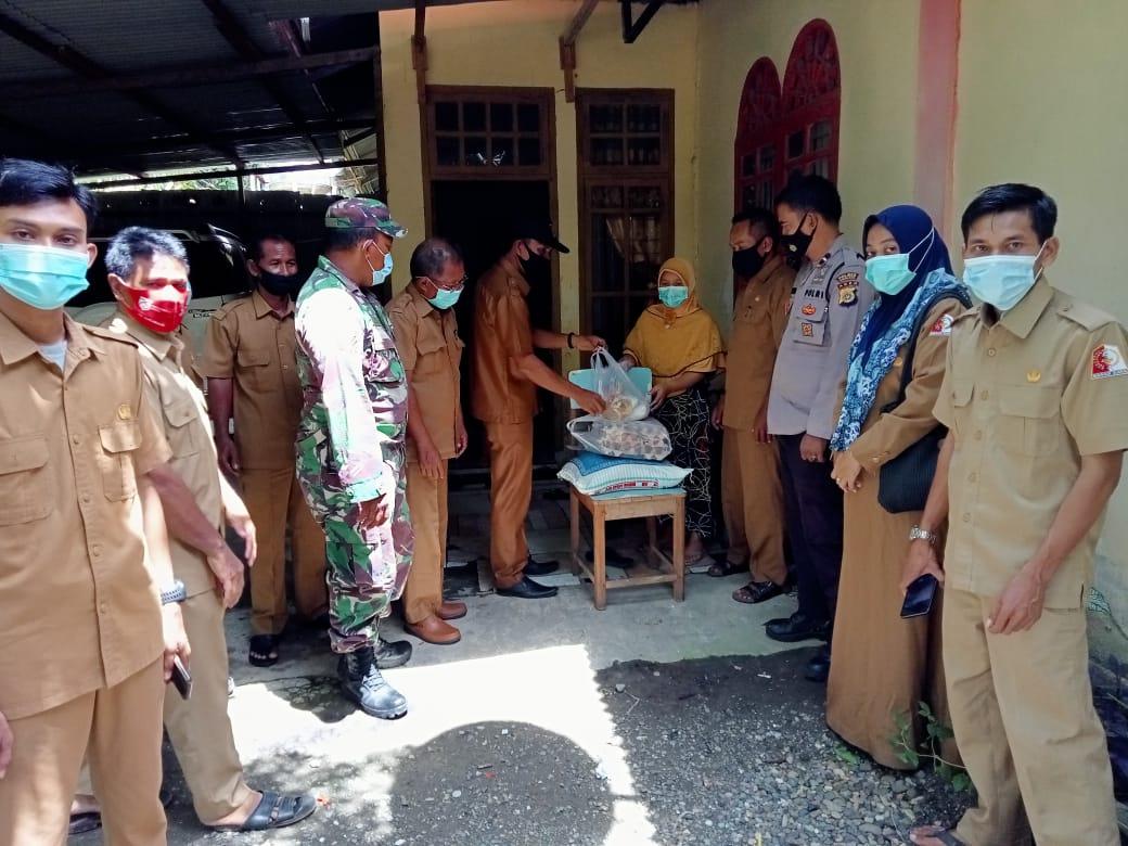 Bersama Aparatur Desa, Babinsa Kuala Trang Salurkan Bantuan untuk Warga Terpapar Covid-19