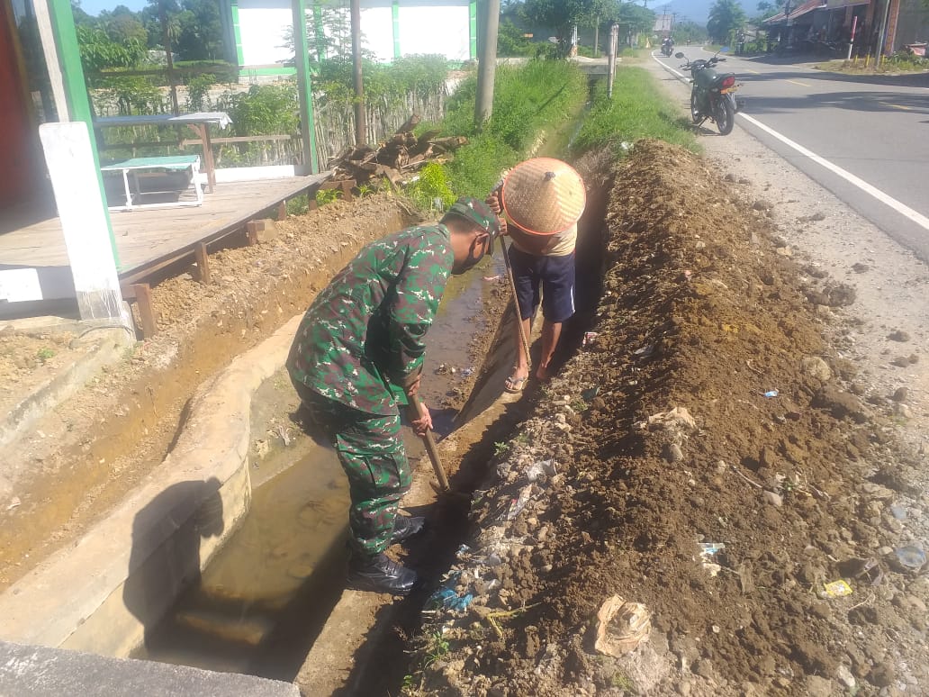 Peduli Kebersihan Lingkungan Sekitar, Babinsa Bantu Warga Bersihkan Parit Jalan