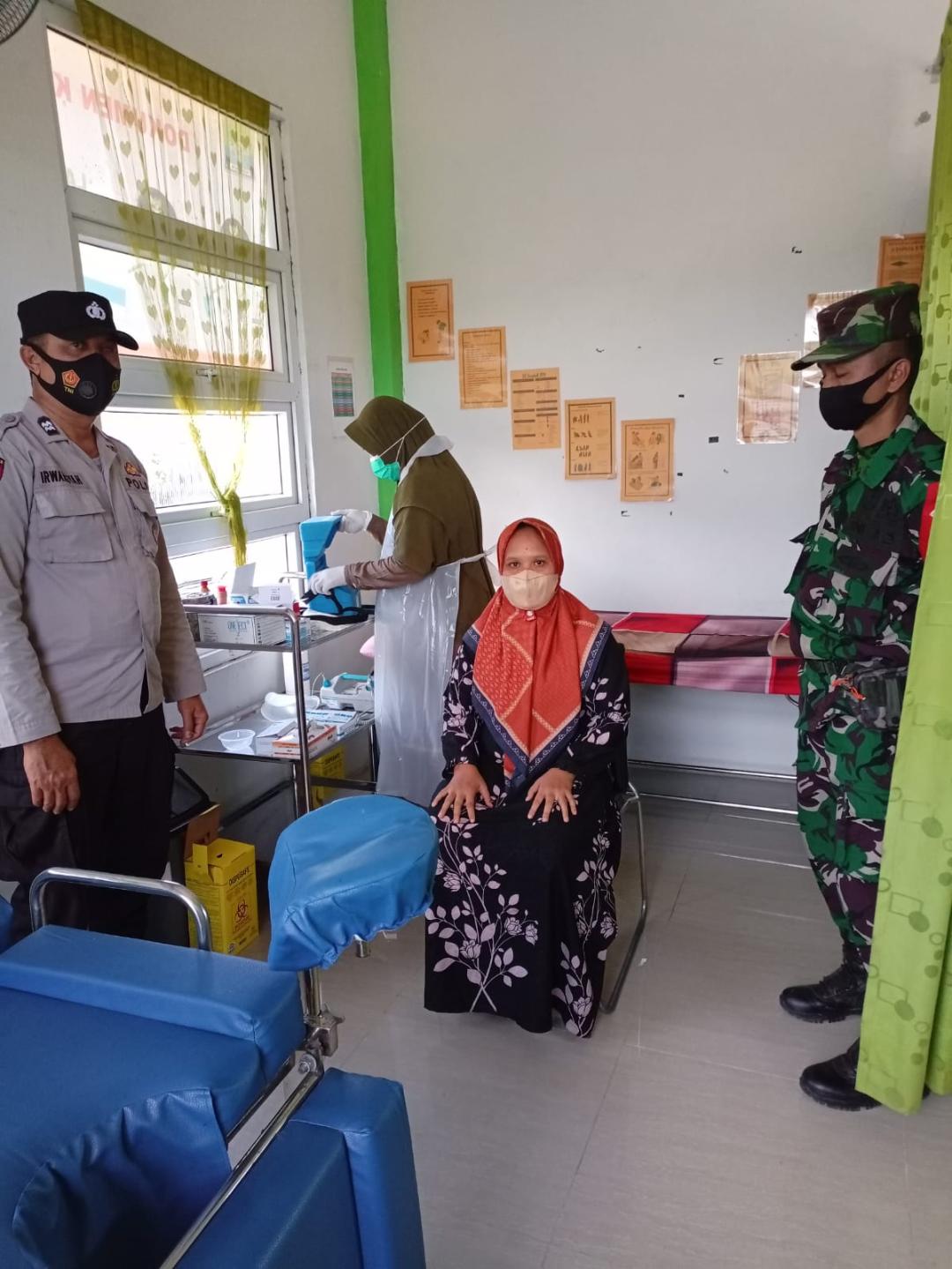 Babinsa Indra Jaya dan Bhabinkamtibmas Dampingi Warga Vaksinasi Covid-19 Tahap Kedua