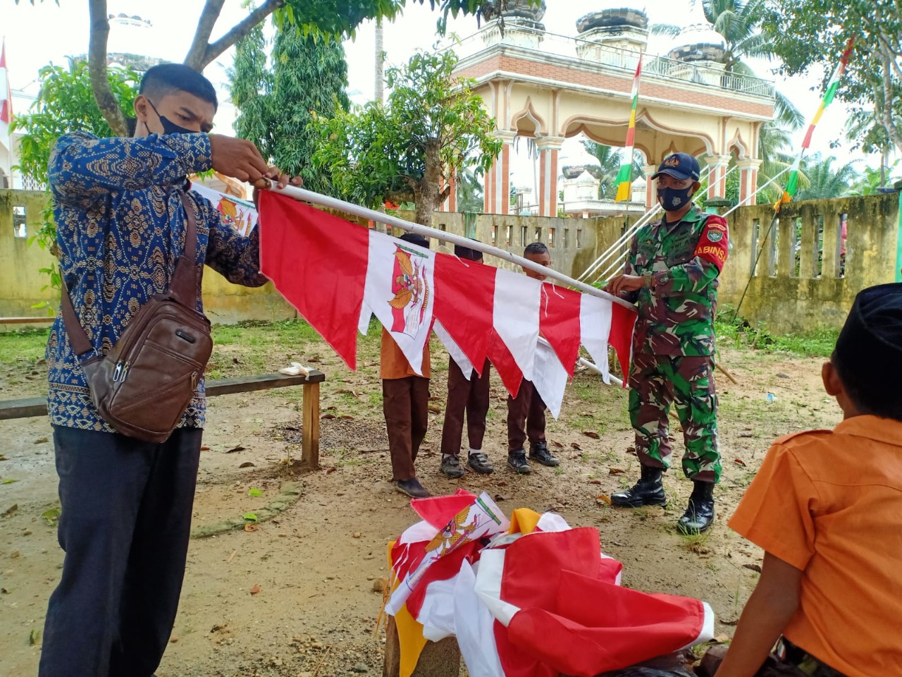 Tanamkan Jiwa Nasionalisme Sejak Dini, Babinsa Koramil 24/Dri Ajak Pelajar MIN Keude Dua Kibarkan Bendra dan Umbul-Umbul