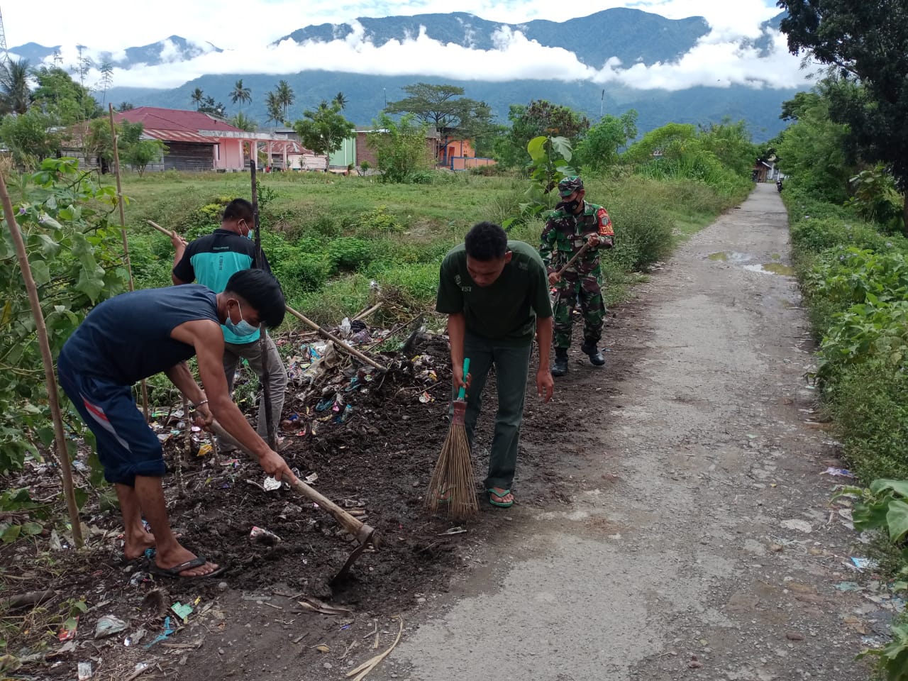 Babinsa Ajak Warga Bersihkan Tumpukan Sampah di Jalan
