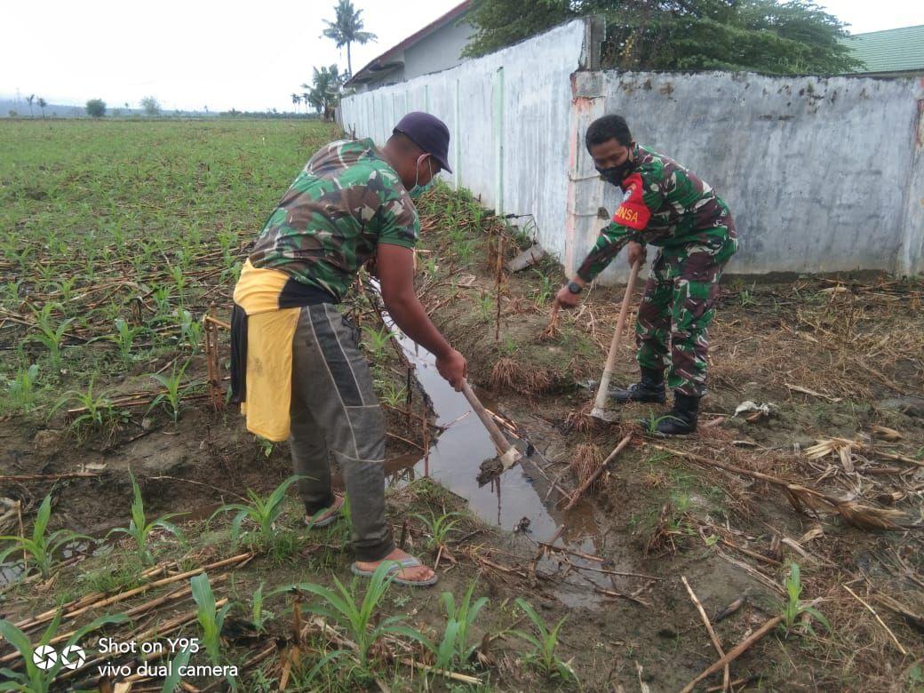MUSIM PENGHUJAN TIBA BABINSA BANTU WARGA BERSIHKAN PARIT KEBUN JAGUNG WARGA