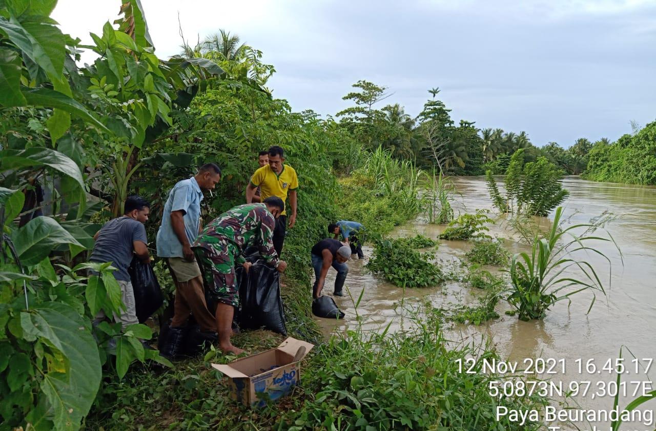 Babinsa Bersama Masyarakat Gotong Royong Buat Tanggul Penahan Air.
