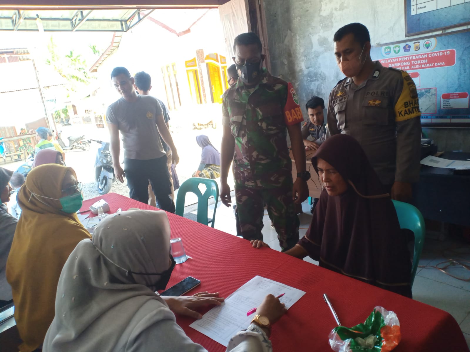 Babinsa Koramil 06/Manggeng Bersama Bhabinkamtibmas Lakukan Pendampingan Vaksinasi di Kantor Keucik