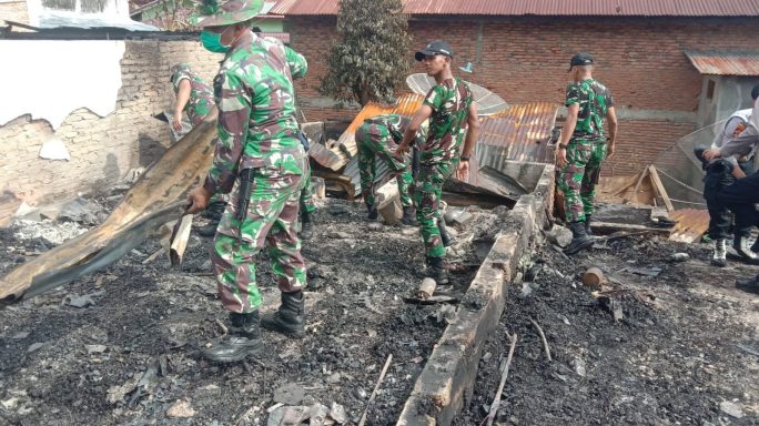 Personel Kipan B Yonif RK 114/SM turut membantu warga membersihkan puing-puing pasca kebakaran