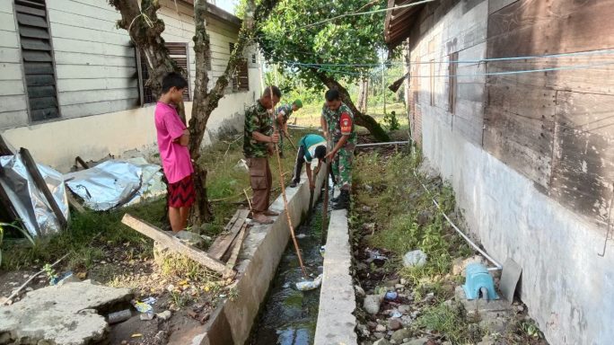 Musim Penghujan Tiba Babinsa Bersama Warga Bersihkan Parit