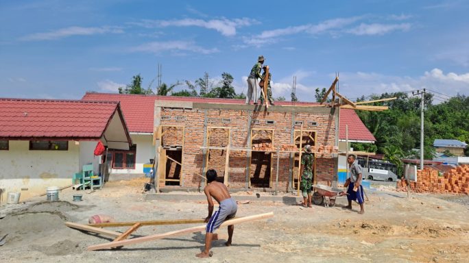 Anggota Satgas TMMD 117, Pasang Tiang Kayu Rangka Atap MCK