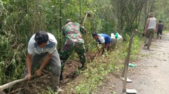 Babinsa Bersama Warga Laksanakan Gotong Royong Bersihkan Parit Kiri Kanan Jalan