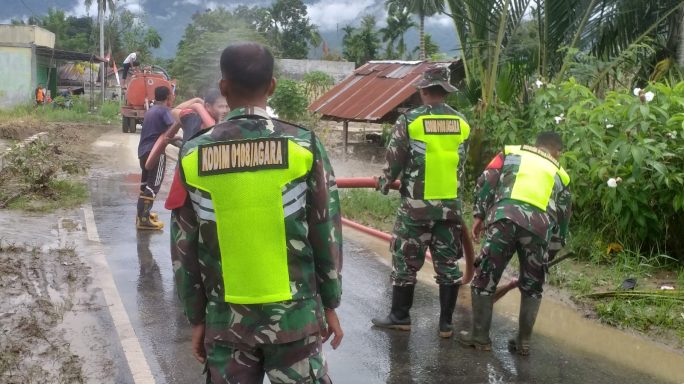 Babinsa Bersama Anggota BPBD Semprot Jalan Bekas Lumpur