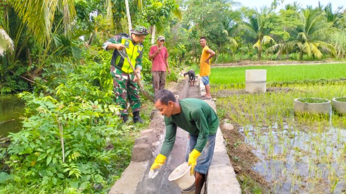 Ringankan Beban Petani, Babinsa Koramil 06/Peusangan Bantu Pembuatan Saluran Air