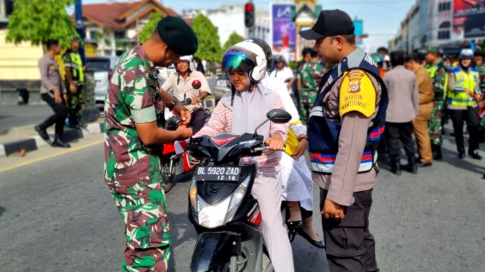 Sambut HUT Kemerdekaan RI ke – 78 Persoel TNI – Polri Bagi bagi Bendera Merah Putih kepada Masyarakat sekitar kota Juang Bireuen.