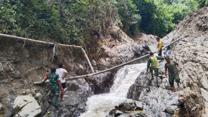 Babinsa Bersama Warga Perbaiki Pipa Saluran Air Bersih Yang Pecah Akibat Banjir