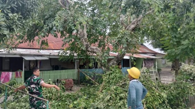 Anggota Koramil 12/Sakti Pantau Petugas PLN Tertibkan Ranting Pohon Yang Memenggagu Instalasi Listrik di Rumdis Asmil Kota Bakti