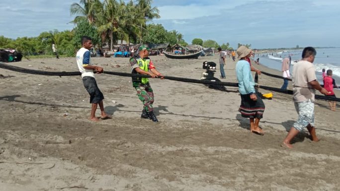 Bantu Tarik Pukat Ikan, Babinsa Posramil Simpang Mamplam Ingatkan Nelayan Jaga Kelestarian Laut