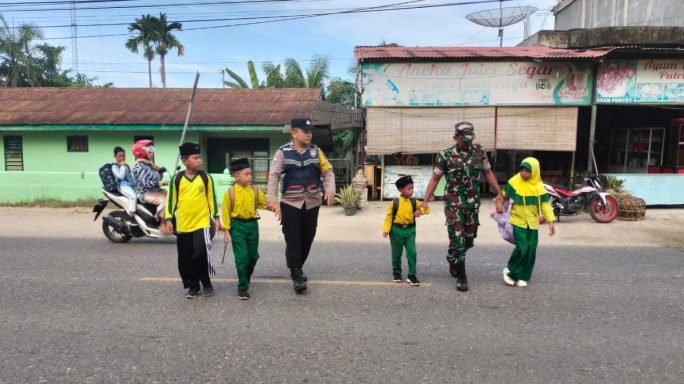 Peduli Keselamatan Pelajar, Dua Babin di Peureulak Bantu Penyebrangan Anak Sekolah