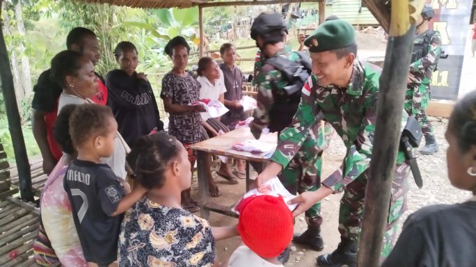 Satgas Pamtas Statis RI -PNG Yonif 111/KB Membagikan Baju NKRI Dari Ster TNI Kepada Masyarakat 