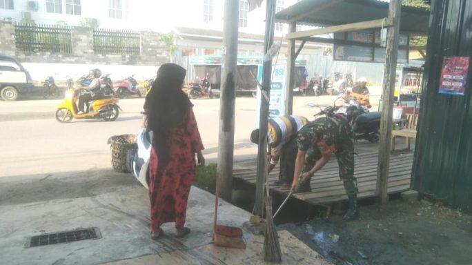 Babinsa Meningkatkan Kebersihan Lingkungan Dengan Bekerja Sama Dengan Warga Dalam Membersihkan Parit