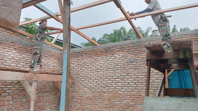 Lanjutkan Rehab RTLH, Satgas TMMD Dibantu Warga Pasang Kayu Untuk Penempatan Atap Rumah