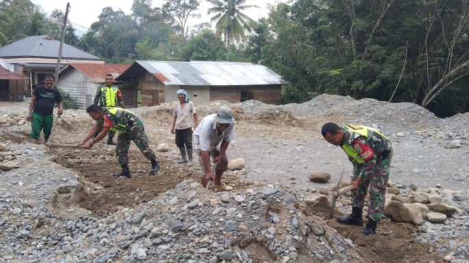 Babinsa Bersama Warga Gotong Royong Meratakan Tanah Timbunan Di lapangan Voly