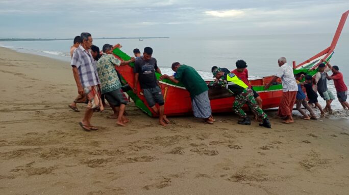 Babinsa Posramil Peulimbang, Bantu Warga Nelayan Sandarkan Perahu ke Bibir Pantai
