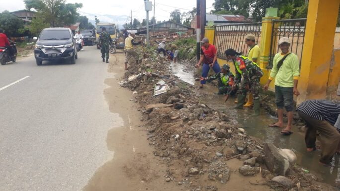 Babinsa Ajak Masyarakat Gotong Royong Bersihkan Parit di Sekitar Jalan Desa