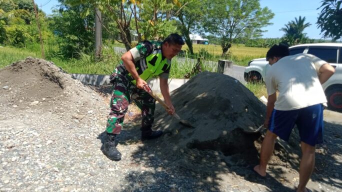 Tunjukan Kemanunggalan TNI Rakyat Babinsa Bantu warga Serakkan Krikil di Jalan