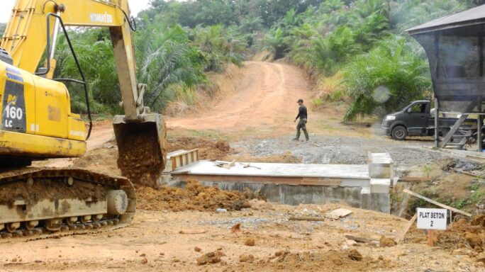 Anggota Satgas TMMD Awasi Penimbunan Tanah Mengunakan Excavator.