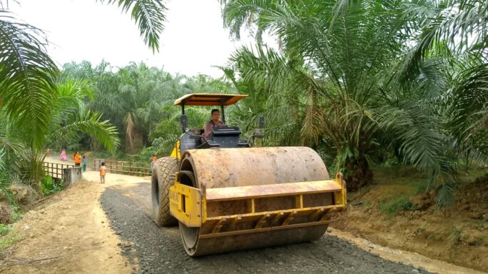 Alat Berat Compactor Ratakan Timbunan Batu Di Pembukaan Jalan TMMD Reguler ke 119 Kodim 0117/Aceh Tamiang.