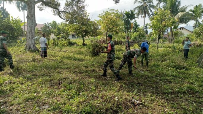 Babinsa Kerja Bhakti Bersama Warga Desa Bersihkan Tempat Pemakaman Umum .